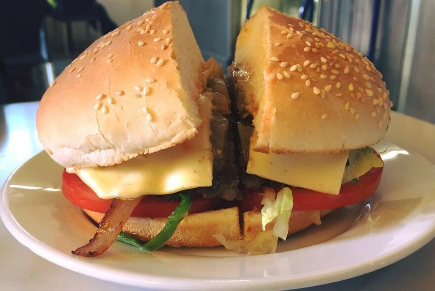 Burger cut in half on a plate.