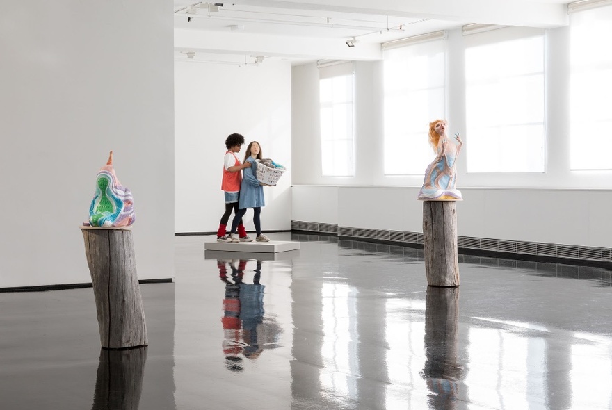 Installation view of a Patricia Piccinini's exhibition of free standing sculptures and figures inside Tolarno Gallery, resting a highly polished black concrete floor, set against white walls.