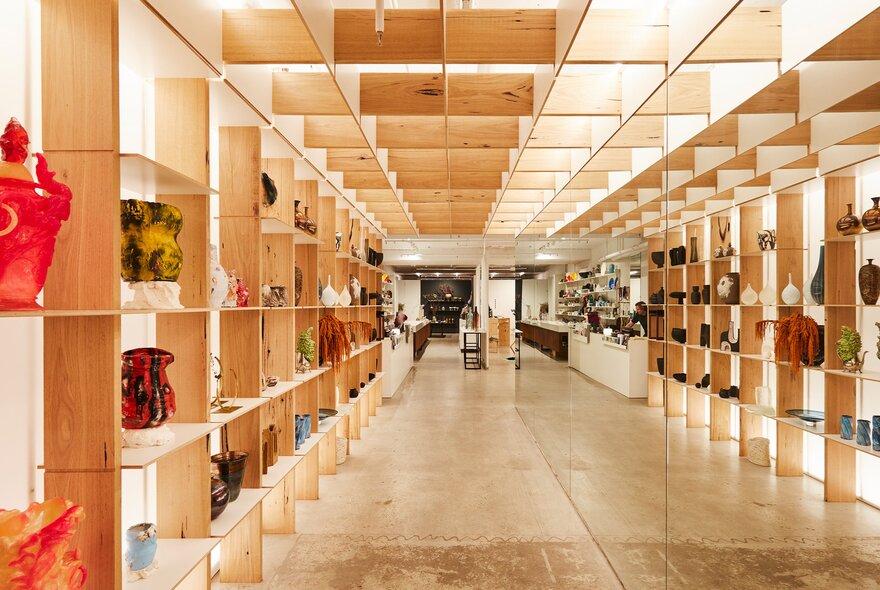 Inside a ceramic store with multiple wooden shelves holding vases and other ceramic items