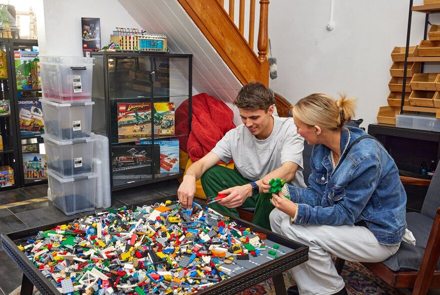 A couple building at a LEGO table.