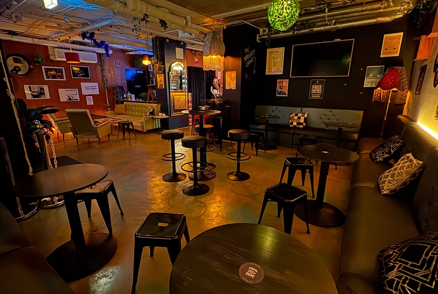 Venue with couches, stool seating and picture frames on the walls.