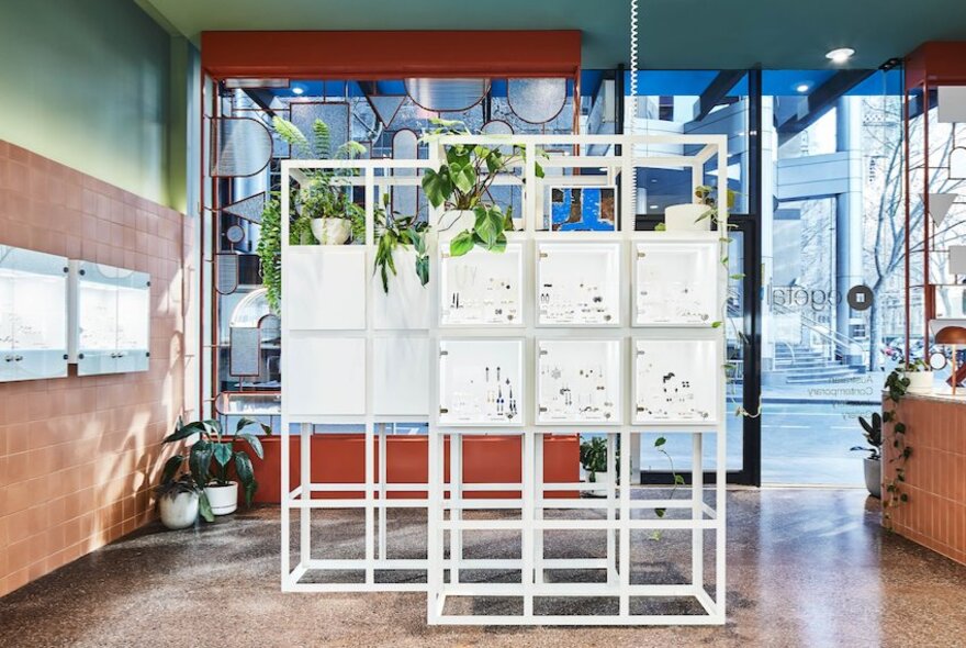 A white cube display shelf inside a jewellery store.