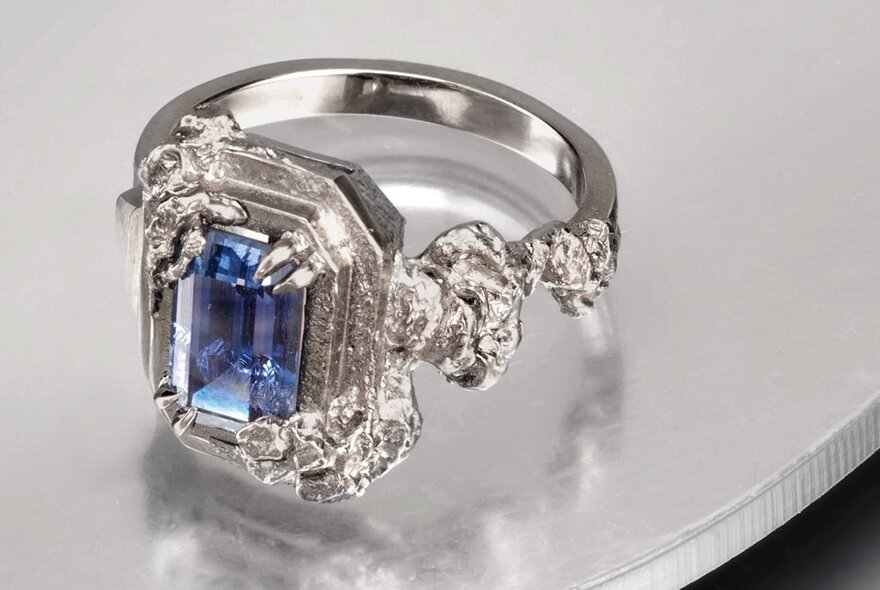 A silver, diamond and sapphire ring.