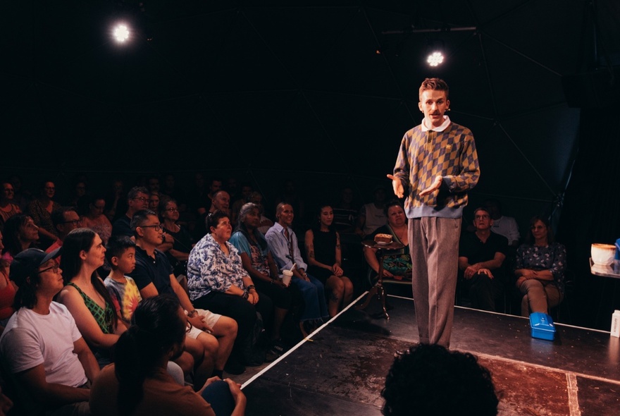 A magician performing to a seated audience.