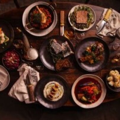 Looking down at a table laden with many dishes of food.