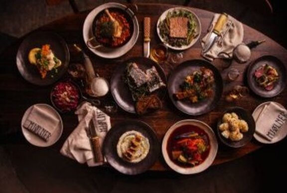 Looking down at a table laden with many dishes of food.