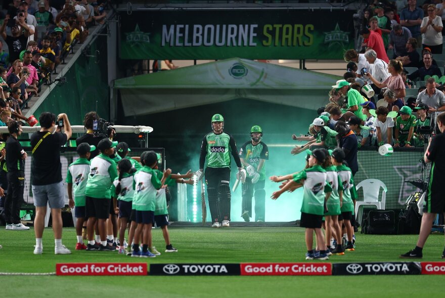Melbourne Stars players emerging onto the ground with a line-up of kids ready to high five them.  