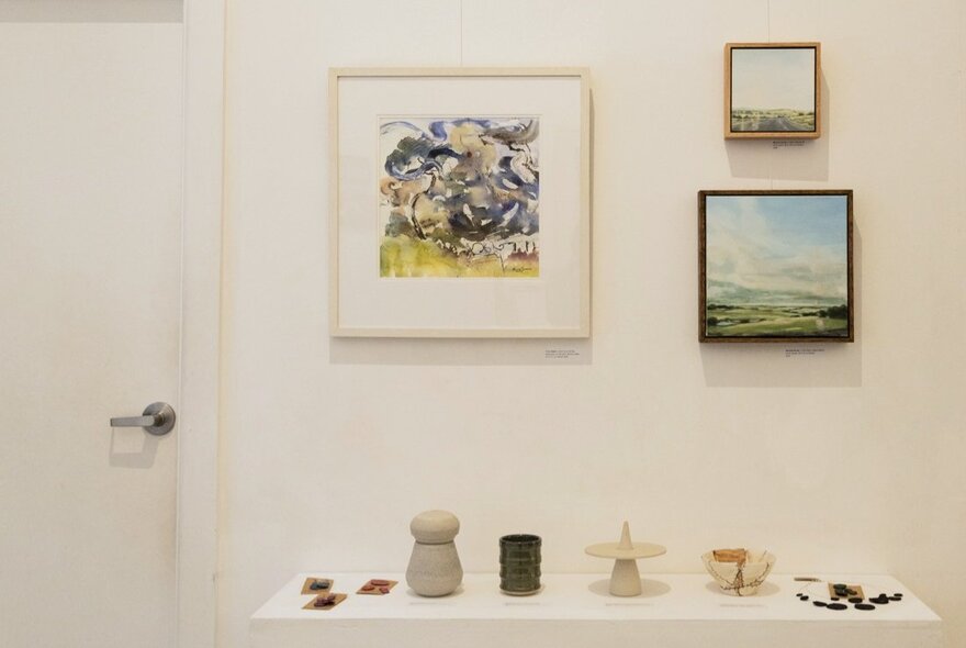 The gallery shop at fortyfivedonwnstairs, a small exhibition space with artworks hanging on the walls and displayed on a wall shelf.