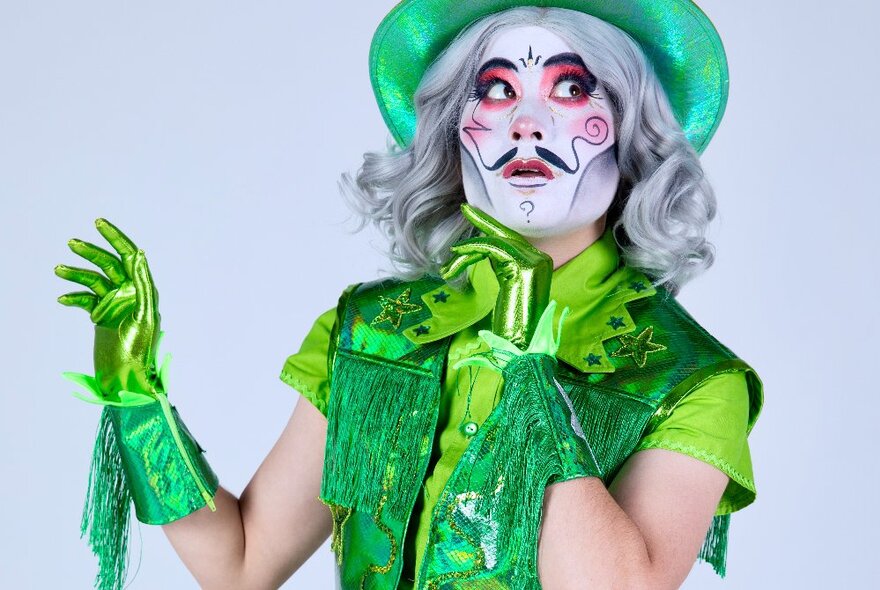 A performer dressed in green with elaborate face make-up. 