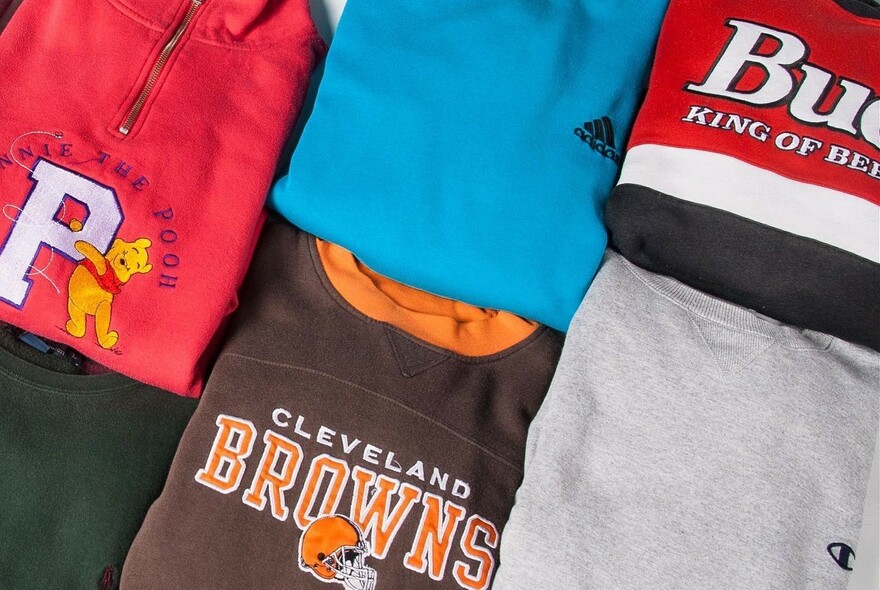 Folded T-shirts with logos and branding.