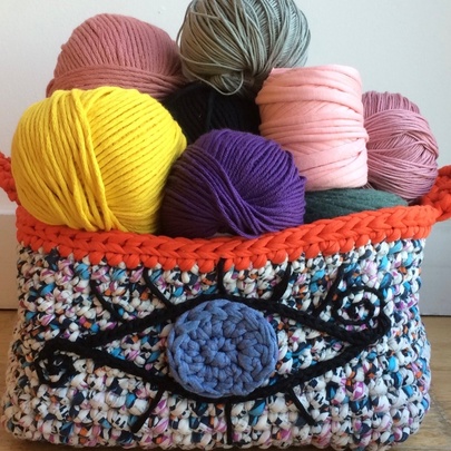 Balls of coloured yarn in a knitted soft basket.