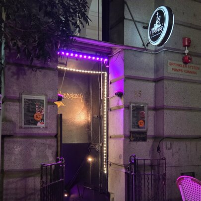 Venue doorway lit by purple and white lights at night, with signage.