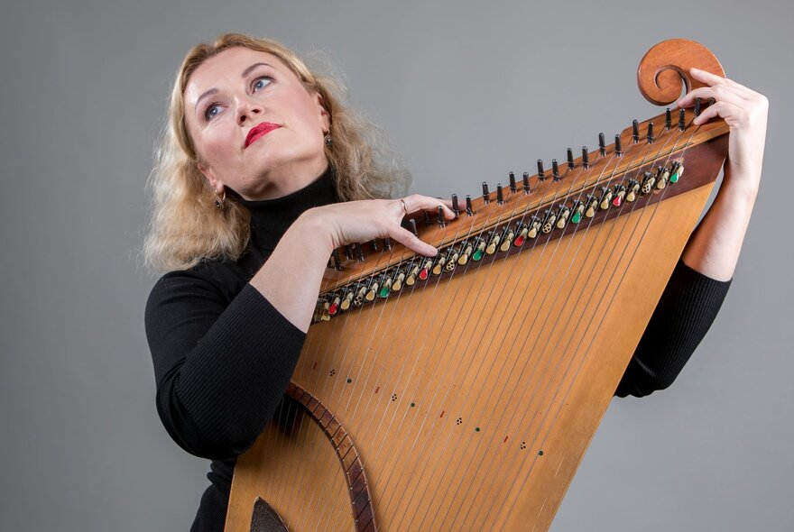 Lithuanian Kanklės performer, Regina Marozienė, posing with her instrument.