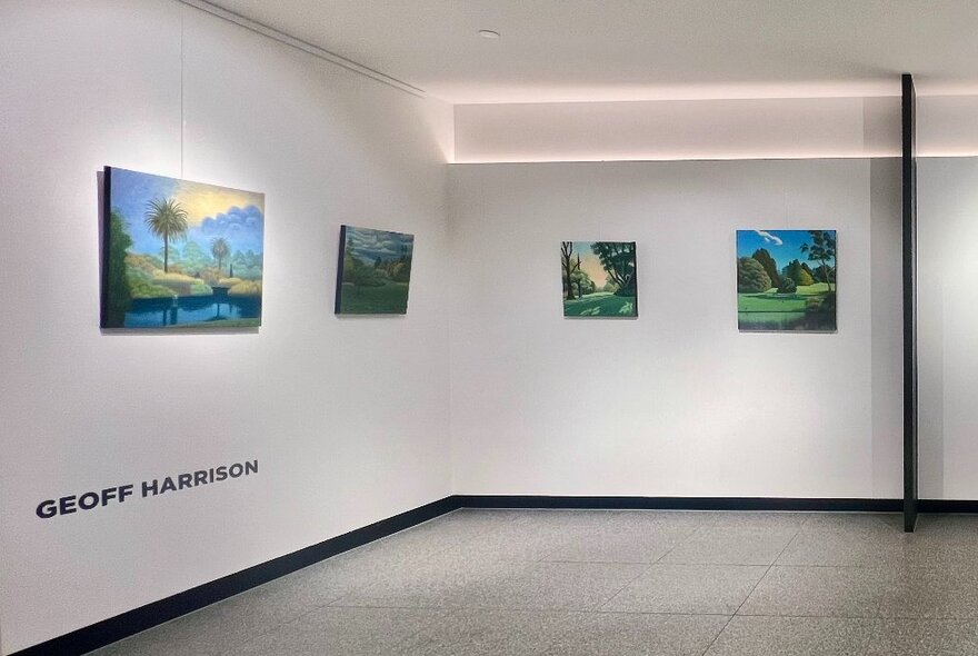 Gallery walls hung with smaller landscape artworks.