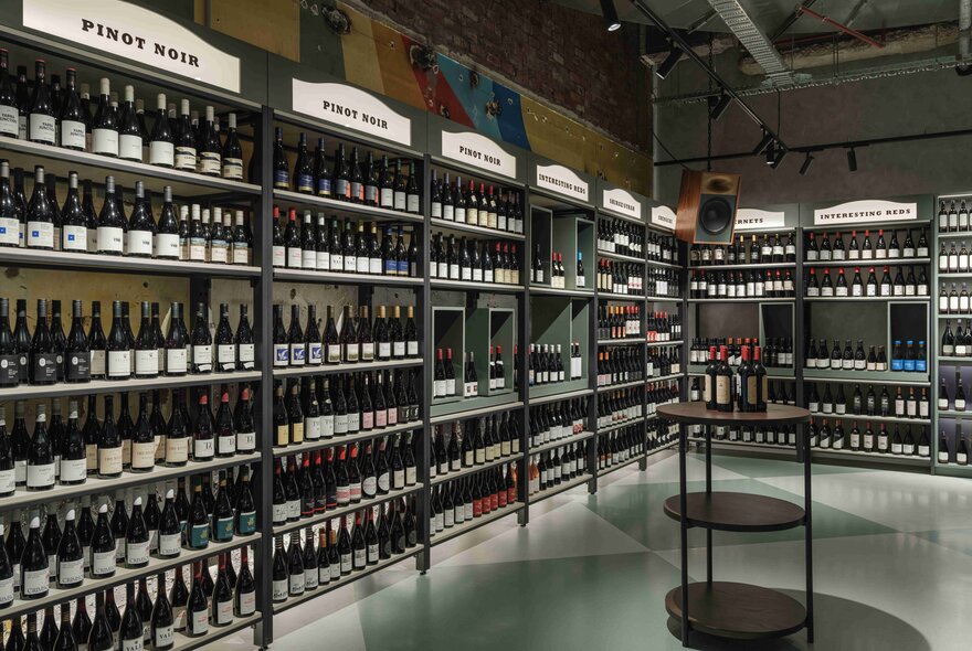 Shelves of wine in an industrial-look cellar.