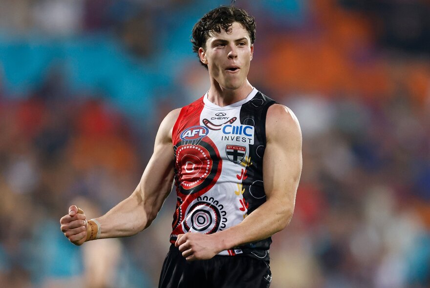 A St Kilda AFL football player with his fists clenched and pumped during a match.