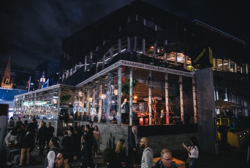 Crowds thronging Federation Square venue at night.