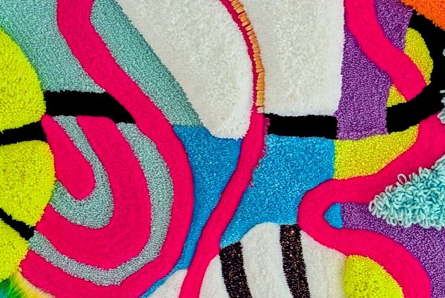 A colourful woven artwork with different textures and patterns representing a map.