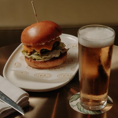 A burger and beer in a restauant.