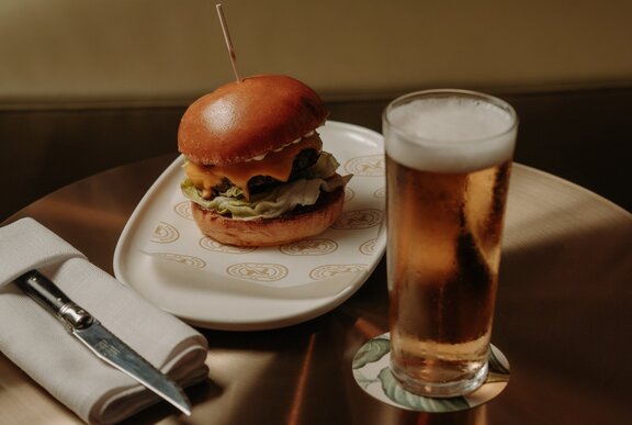 A burger and beer in a restauant.