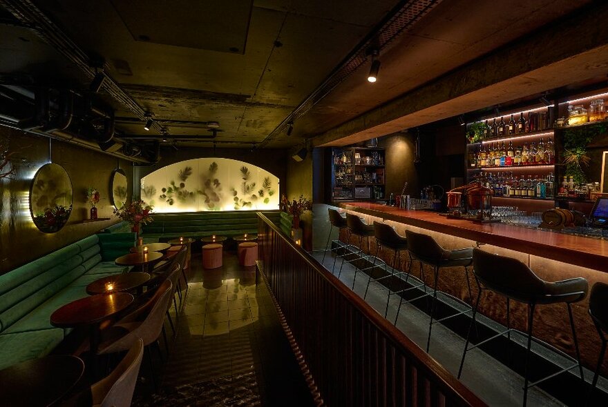 Interior of Bar Clara, showing banquette seating and bar service area with high stools.