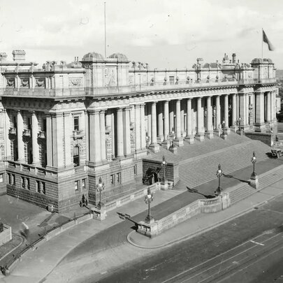 Historic aerial black and white photograph of the grand, classical facade of Parliament House in Melbourne.