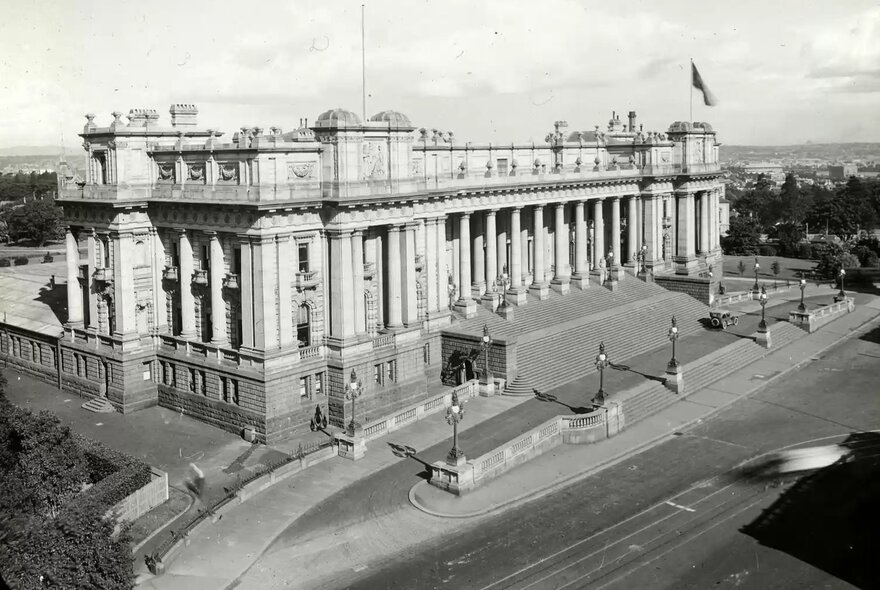 Historic aerial black and white photograph of the grand, classical facade of Parliament House in Melbourne.