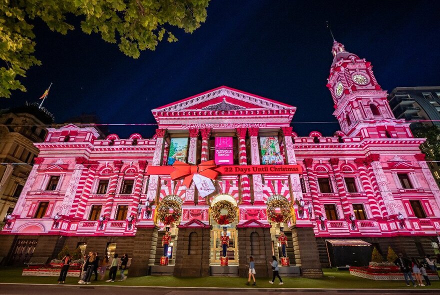 Melbourne Town Hall facade lit up with pink Christmas projections.