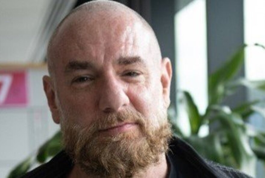 Bald man with a beard, looking directly at the viewer.