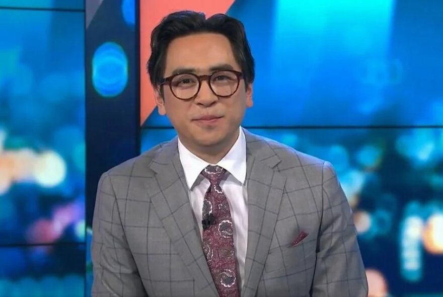 Portrait of comedian, Michael Hing, on the set of the TV show, The Project, wearing a suit and tie.