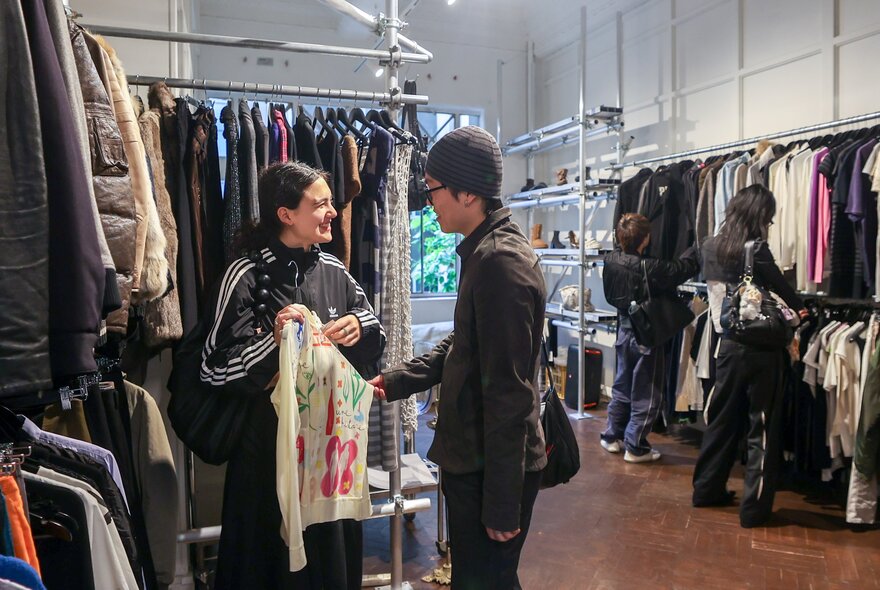 Two people interacting in a clothes store. 