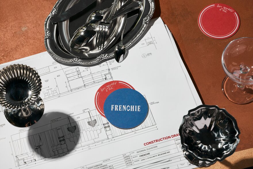 Glasses of wine with placemats on architectural drawings.