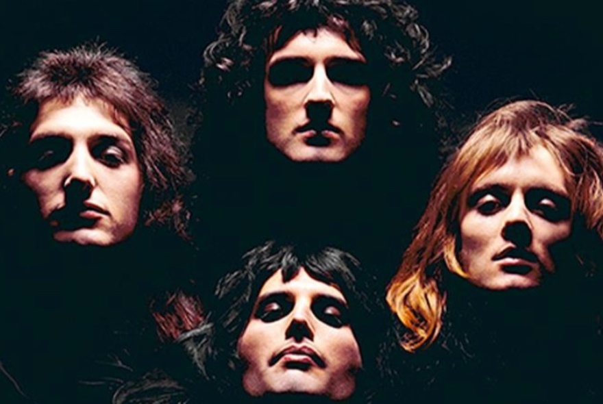 Underlit faces of rock group Queen from Bohemian Rhapsody era.