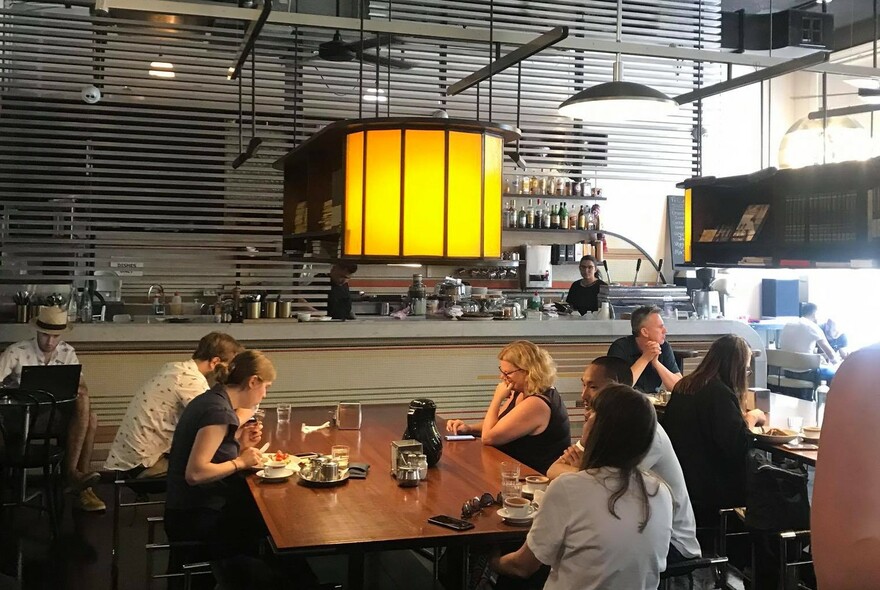 Group of people seated at a table inside cafe