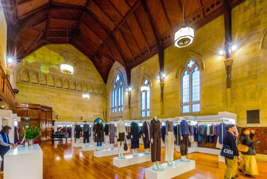 The interior of a designer store with vaulted ceilings and rows of mannequins.