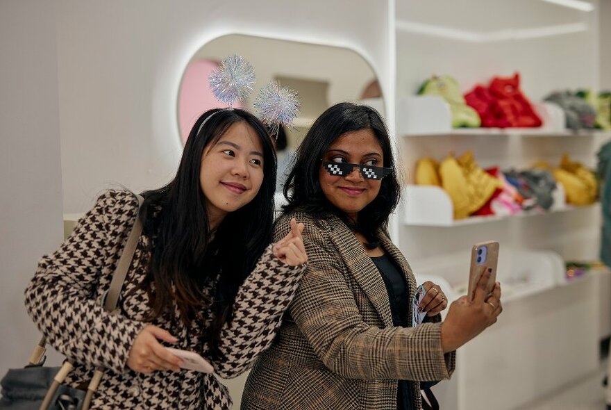 Two girls posing with sparkly headband and sunglass props.