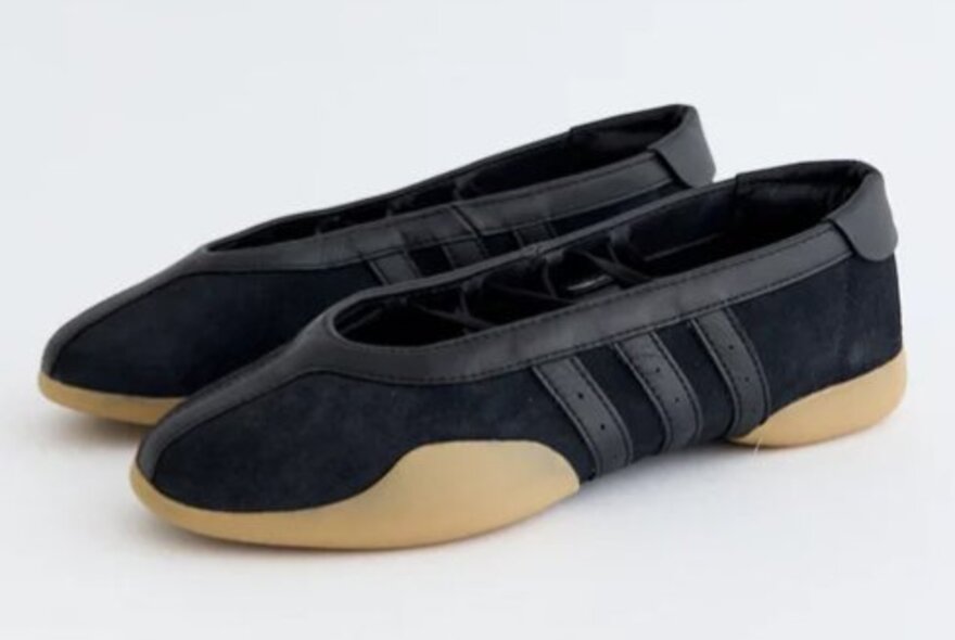 A pair of black ballet flats with Adidas's signature three stripes.
