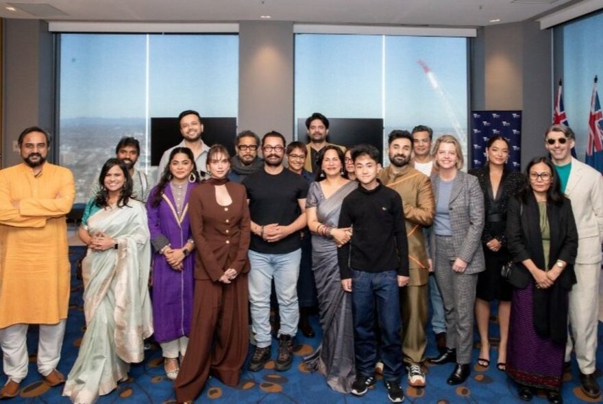 A group of people gathered for a group shot, some in Indian dress. 