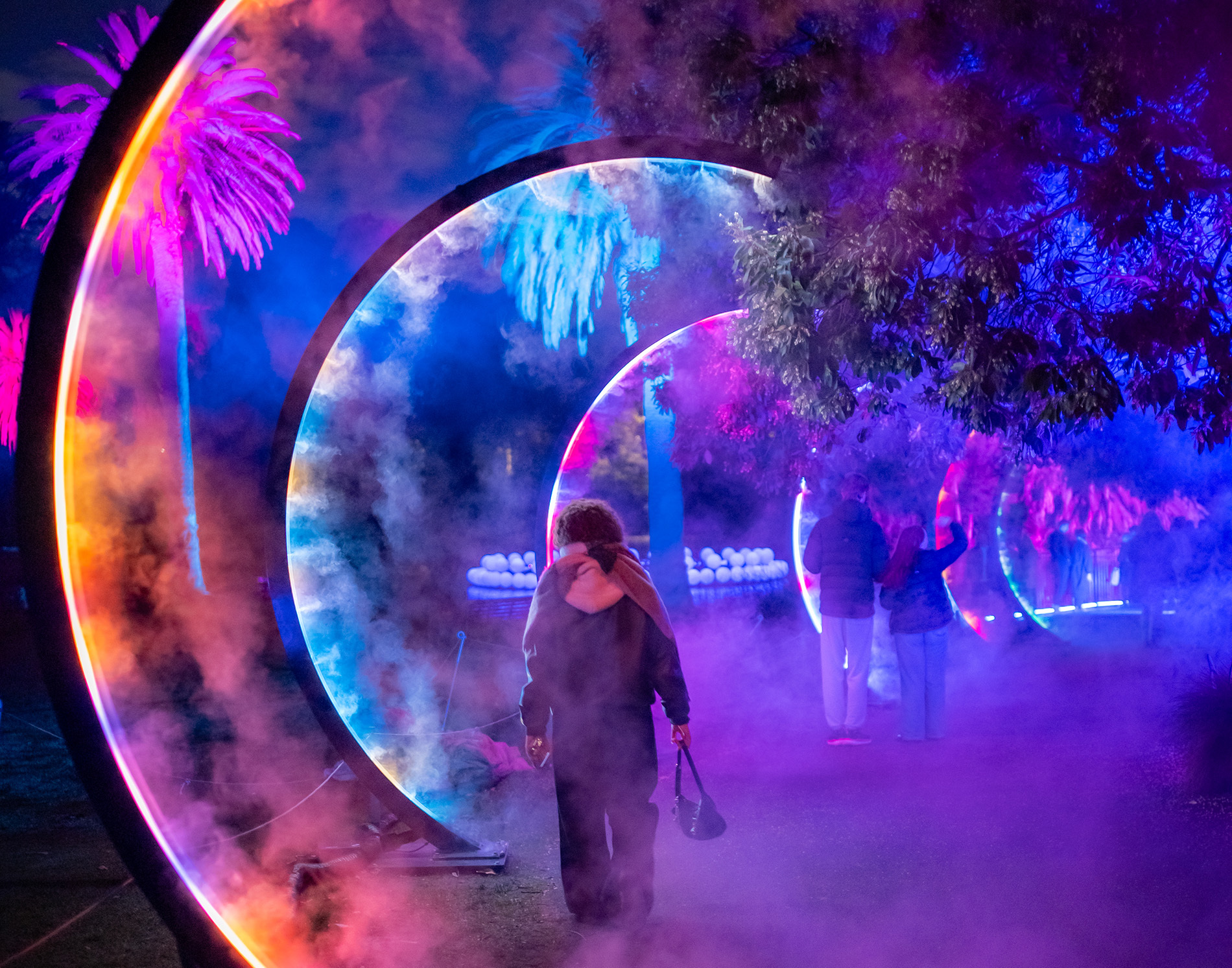 A girl walking through curved misty light poles.