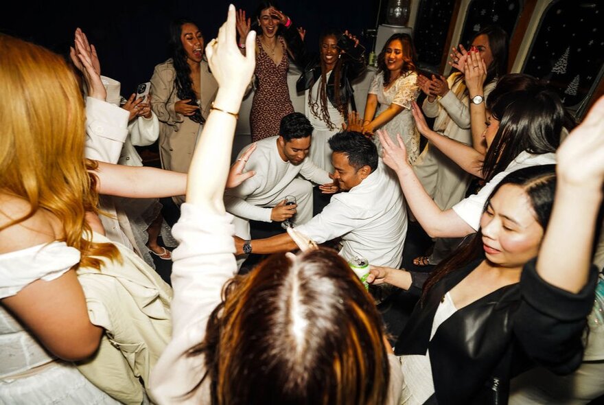 A crowd of people on a dancefloor.