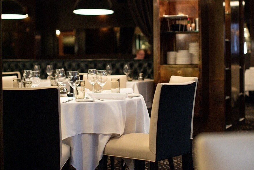 Restaurant table with white tablecloth and glasses. 