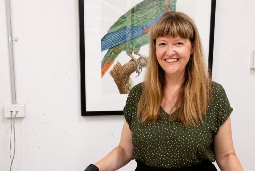 A smiling woman with long straight hair in the library of Melbourne Museum.