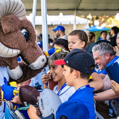 The LA Rams mascot, Rampage, greeting fans and signing NFL footballs.