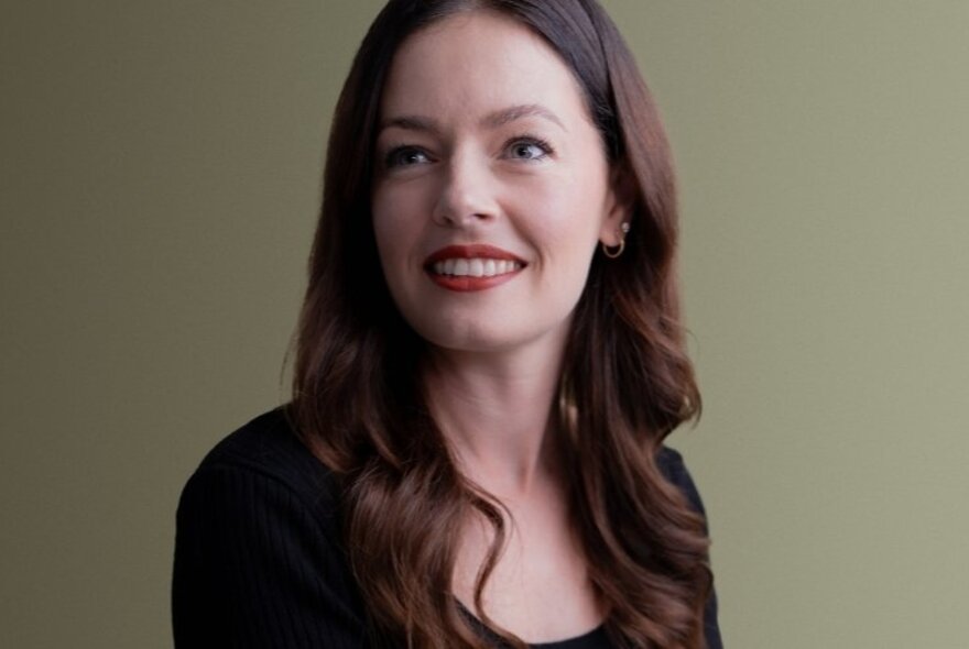 Head and shoulders portrait of author Stacey McEwan, her head turned slightly to one side, her long brown hair falling past her shoulders.