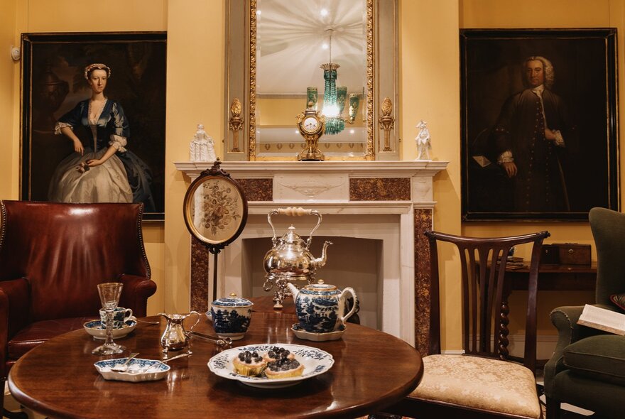 Formal drawing room with breakfast table and antiques.