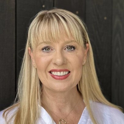 Australian children's author Jacqueline Harvey, smiling at the viewer, with long blond hair framing her face.