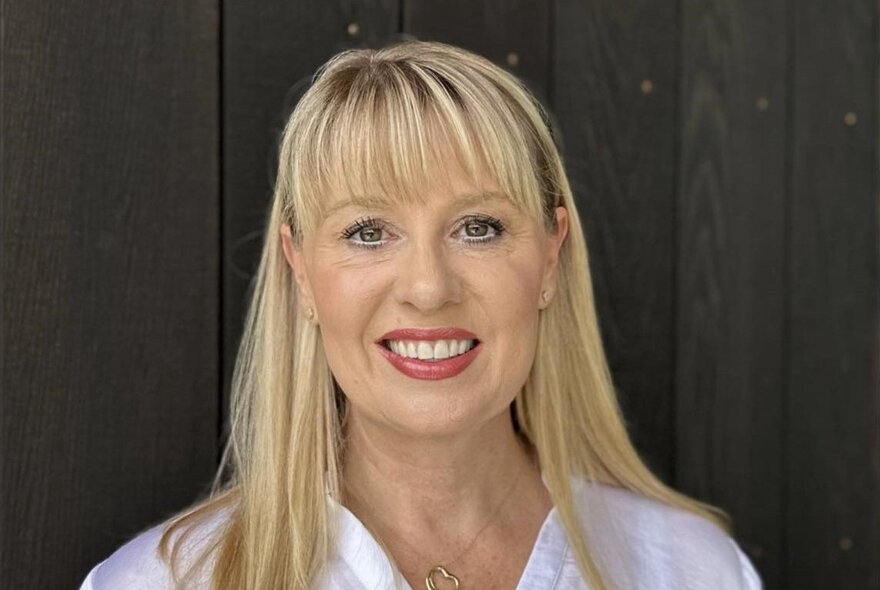 Australian children's author Jacqueline Harvey, smiling at the viewer, with long blond hair framing her face.