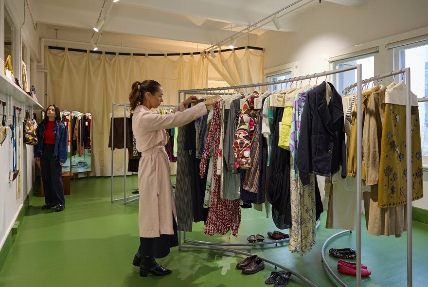 A woman is looking at clothing in a clothing store