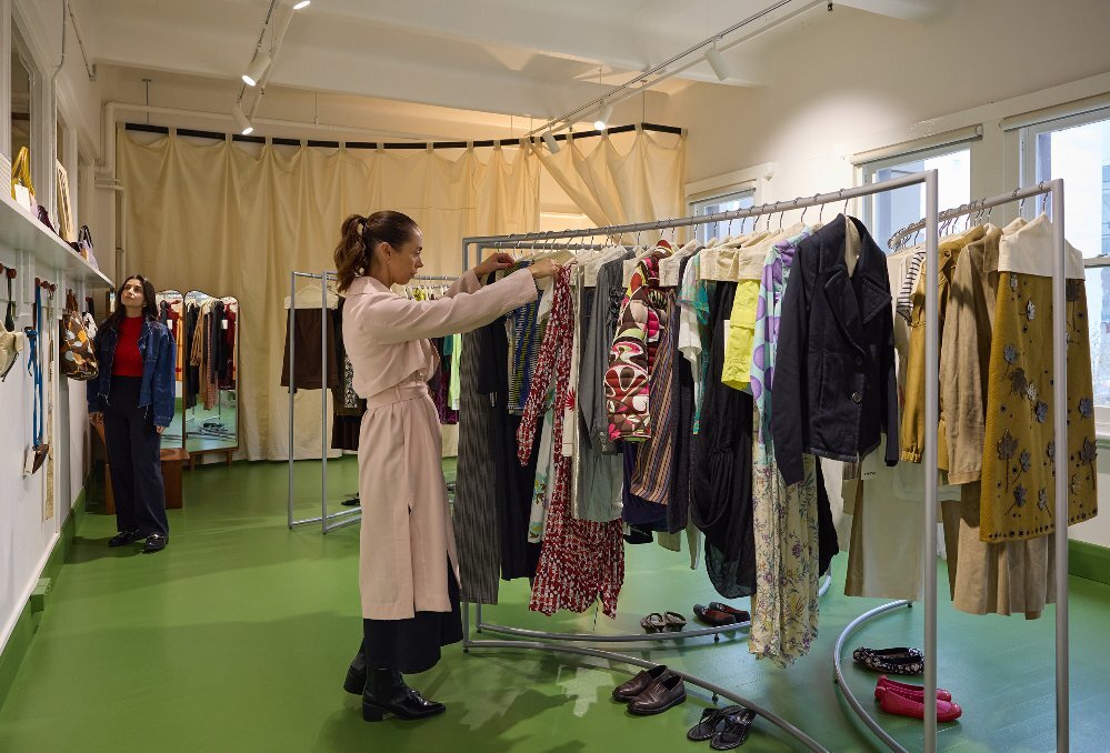 A woman is looking at clothing in a clothing store