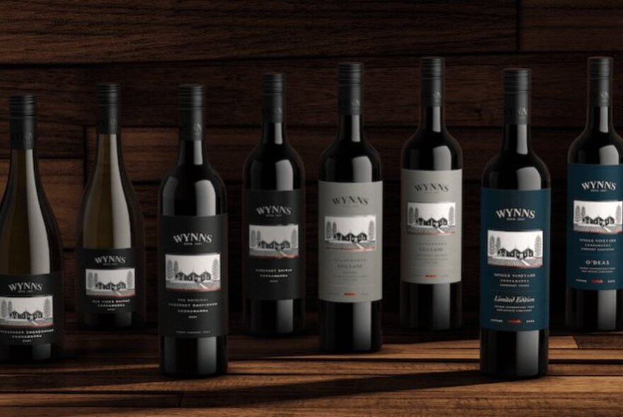 A lineup of Wynns Coonawarra Estate wines, on a wooden table.